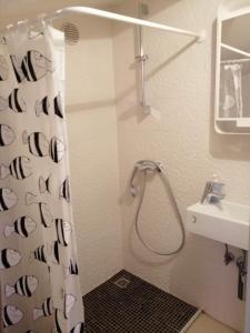 La salle de bains est pourvue d'un rideau de douche et d'un lavabo. dans l'établissement Studio apartment in Funtana with balcony, air conditioning, WiFi, washing machine 4982-2, à Funtana