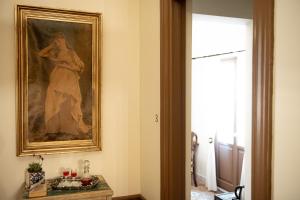 Un dipinto di una donna appesa a un muro in una stanza di Beautiful City Suites ad Atene