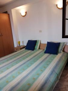 1 dormitorio con 1 cama grande con almohadas azules en Studio apartment in Funtana with balcony, air conditioning, WiFi, washing machine 4982-8, en Funtana