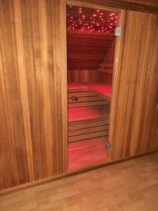 una puerta abierta a un pequeño armario con alfombra roja en La Marilon en Veurne