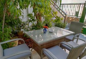 a table with two chairs and a vase on it at Cleopatra's House Apartments in Archangelos +44 photos