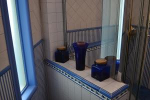 4 vasi blu seduti su una mensola in bagno di Casa Mariannina a Maiori
