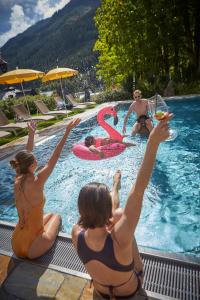 - un groupe de femmes assises autour d'une piscine dans l'établissement Hotel Saalbacher Hof, à Saalbach-Hinterglemm