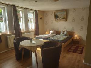ein Wohnzimmer mit einem Bett, einem Tisch und Stühlen in der Unterkunft Ferienapartmenthaus am Rittertor in Stolberg i. Harz