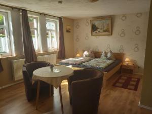 a living room with a bed and a table and chairs at Ferienapartmenthaus am Rittertor in Stolberg i. Harz