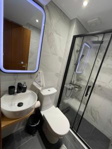 een badkamer met een toilet, een wastafel en een douche bij Q luxury rooms Perea center in Perea