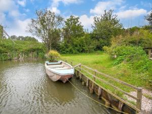 un pequeño barco amarrado a un muelle en el agua en Fantastic villa in Ooltgensplaat with jetty, en Ooltgensplaat