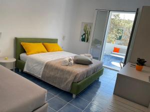 una camera da letto con un letto con cuscini gialli e arancioni di ITINERA Baia Verde Rooms and Breakfast a Gallipoli