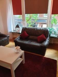 a living room with a leather couch and a table at Riposo in Emden