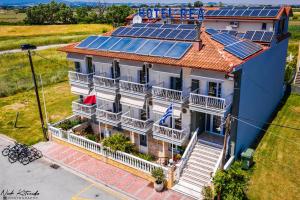 a house with solar panels on the roof at Rea Hotel in Paralia Katerinis