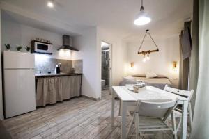 uma cozinha e sala de estar com uma mesa e um frigorífico em Vivienda turística Lagarto de Jaén em Jaén