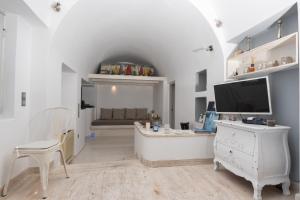 Uma TV ou centro de entretenimento em Hyperion Oia Suites