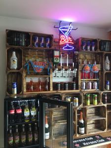 a bar with many bottles of beer and a neon sign at Stadtferienwohnung in Müllheim