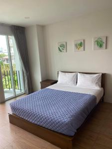 Un dormitorio con una cama grande con un edredón azul. en TEAK VILLA, en Bangna