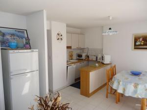 uma cozinha com uma mesa e um frigorífico branco em Appartement climatisé avec grande terrasse plein sud em Cavalaire-sur-Mer