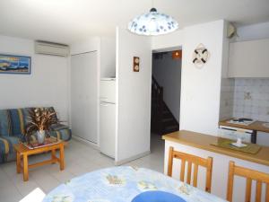 uma cozinha e uma sala de estar com uma mesa em Appartement climatisé avec grande terrasse plein sud em Cavalaire-sur-Mer