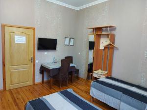 a room with a table and a bed and a door at Готель "Монастирський" in Putyvlʼ