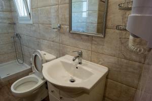 a bathroom with a sink and a toilet and a mirror at Rea Hotel in Paralia Katerinis +38 photos