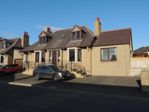 una casa con una macchina parcheggiata di fronte di Heatherlea a Kirkwall