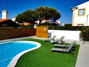 un patio con piscina, sillas y una casa en FamilyHost Charm Porto Covo en Porto Covo
