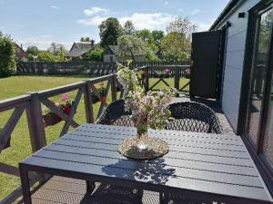 a blue picnic table with a vase of flowers on it at Zemzari in Jūrkalne +14 photos