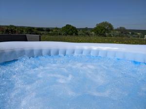 a hot tub filled with water in a yard at Foxhill Lodges in Canterbury