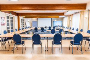 une grande salle de conférence avec une grande table et des chaises dans l'établissement Hotel Pistono, à Dieblich