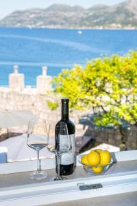 uma garrafa de vinho e dois copos numa mesa em Kanavelic place - Old town Korcula em Korčula