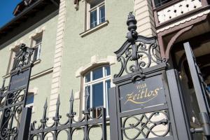 a building with a wrought iron sign in front of it at VILLA zeitlos - PfauenAuge in Traunstein