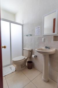 a bathroom with a toilet and a sink at Hotel Casa Garatusa in Yuriria