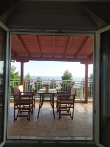 a screened in porch with a table and chairs at Aegean View Seaside Apartment in Kavála