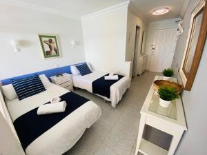 a small room with two beds and a table at Beach Apartment 3 in Patalavaca