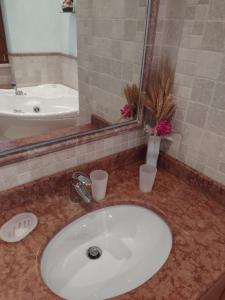 a bathroom with a sink and a mirror and a tub at Mazzini Affittacamere in Viareggio
