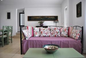 a living room with a purple couch and a table at Chrysiida Suites in Tersanas