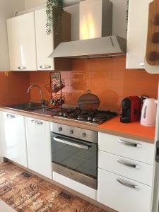 多莫多索拉的住宿－B&B La Terrazza，厨房配有白色橱柜和炉灶烤箱。