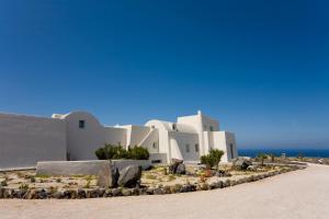 a white building on the beach with the ocean in the background at Black Rock in Akrotiri