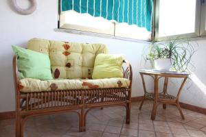 un sofá sentado bajo una ventana junto a una mesa en Rooms Torcello - with shared bathroom, en Portorož