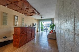 a living room with a wooden cabinet and a couch at Hotel Casa Garatusa in Yuriria