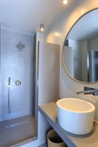 a bathroom with a large round sink and a mirror at Iliades Luxury Boutique Suites in Batsi