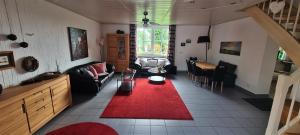 sala de estar con sofá y alfombra roja en Ferienwohnung in Brand Finkenhöhe, en Brand
