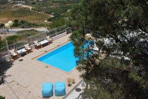 una vista aérea de una piscina con tumbonas azules en Chrysiida Suites, en Tersanas