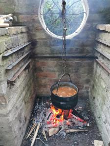 una olla de sopa colgando sobre un fuego en Helesfa Vendégház, en Helesfa