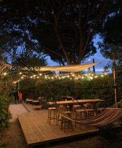 a hammock in a garden with lights at night at Camping Dolce Sole in Marina di Massa