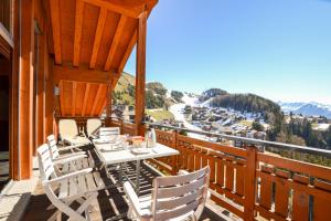 a porch with a table and chairs on a balcony at Casa Arturo Penthouse in Riederalp