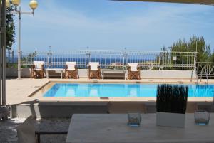 a large swimming pool with chairs and a table at Chrysiida Suites in Tersanas
