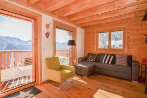 a living room with a couch and a chair at Hirschfluh Duplex in Riederalp