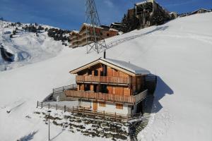 里德拉爾普的住宿－Hirschfluh Duplex，一座带滑雪缆车的雪覆盖的山上的建筑