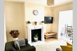 a living room with a couch and a fireplace at A beautiful modern home close to Central London in Goodmayes