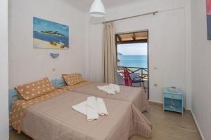 a bedroom with two beds and a view of the ocean at Spiros and Polyxeni Apartments Afionas in Afionas