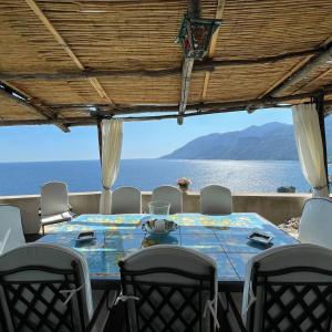 mesa de comedor con sillas y vistas al océano en Villa Anna, en Maiori